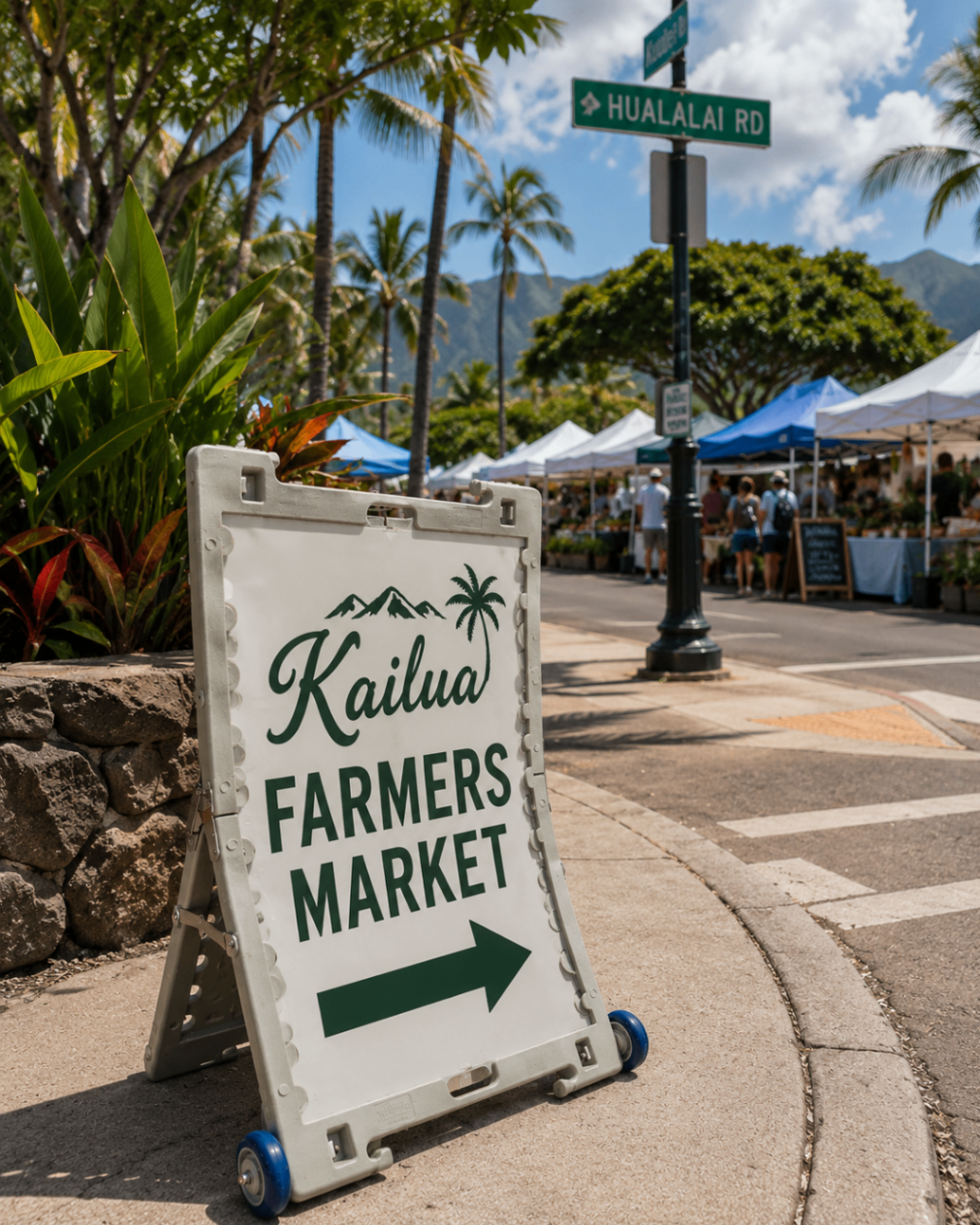 TrYfold sign at a Hawaii farmers market with tents and shoppers in the background.